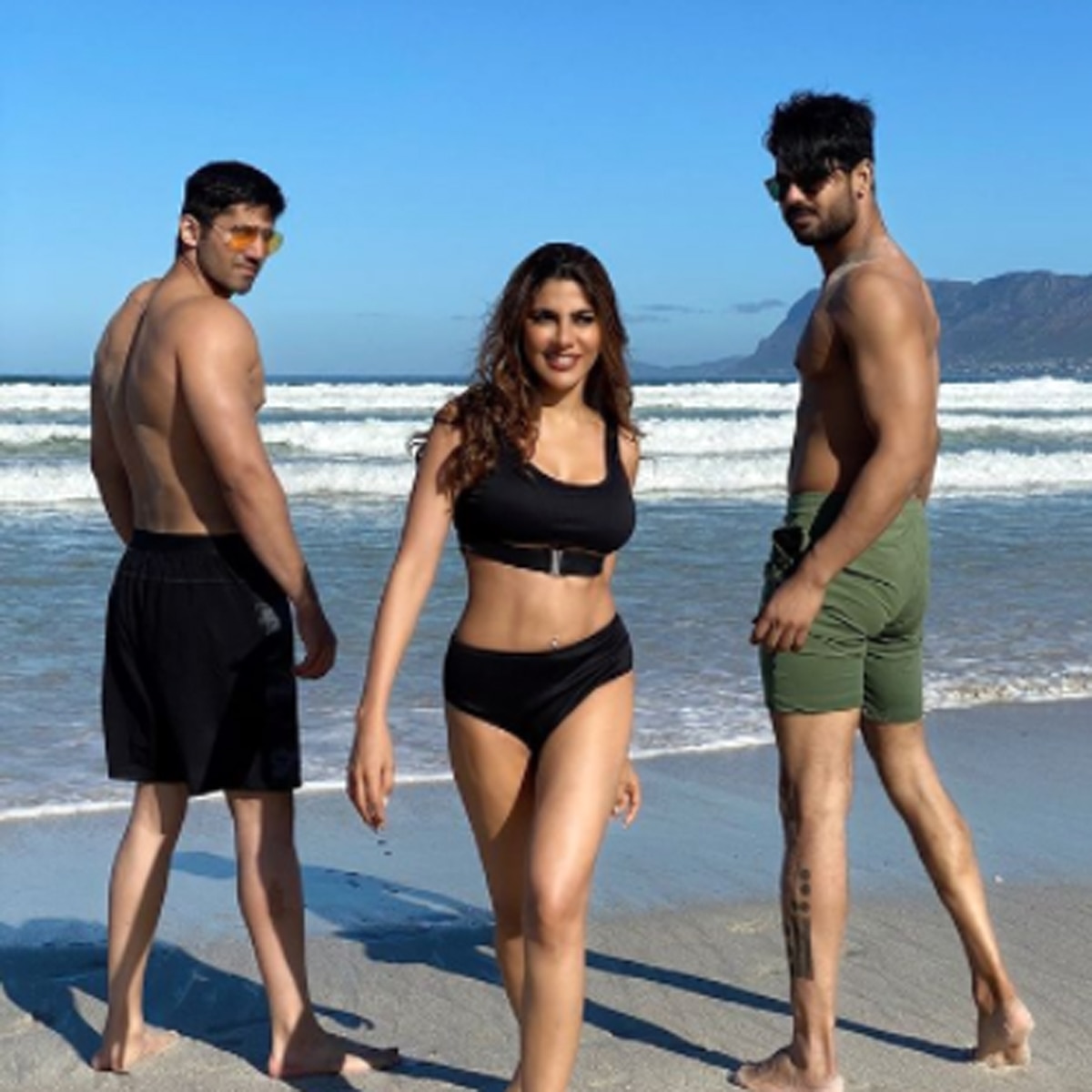 Bigg Boss 14 contestant Nikki Tamboli poses with a glamorous look in a black bikini, posing with Varun-Vishal